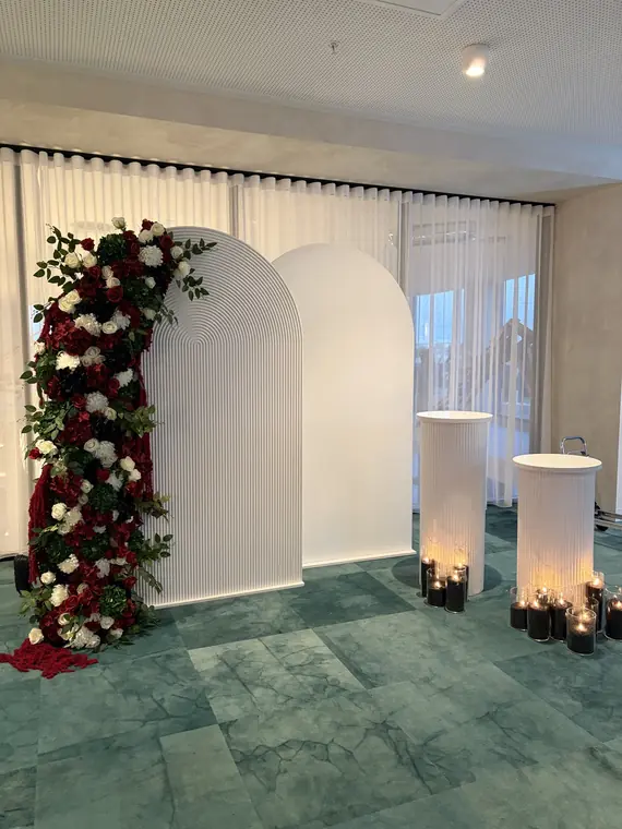 Arch backdrop with cascading red and white floral installation